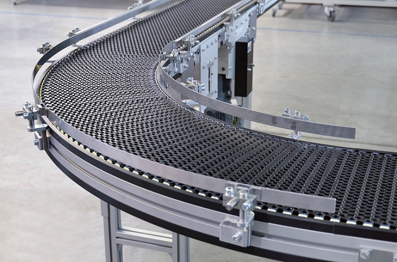 Black plastic modular belt conveyor with a curve
